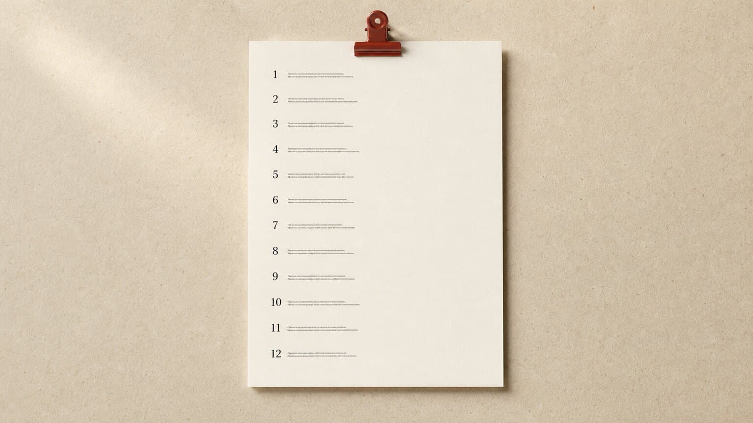 A printed list of numbered questions on a desk beside an open laptop, with a few of the answers marked in the margin.