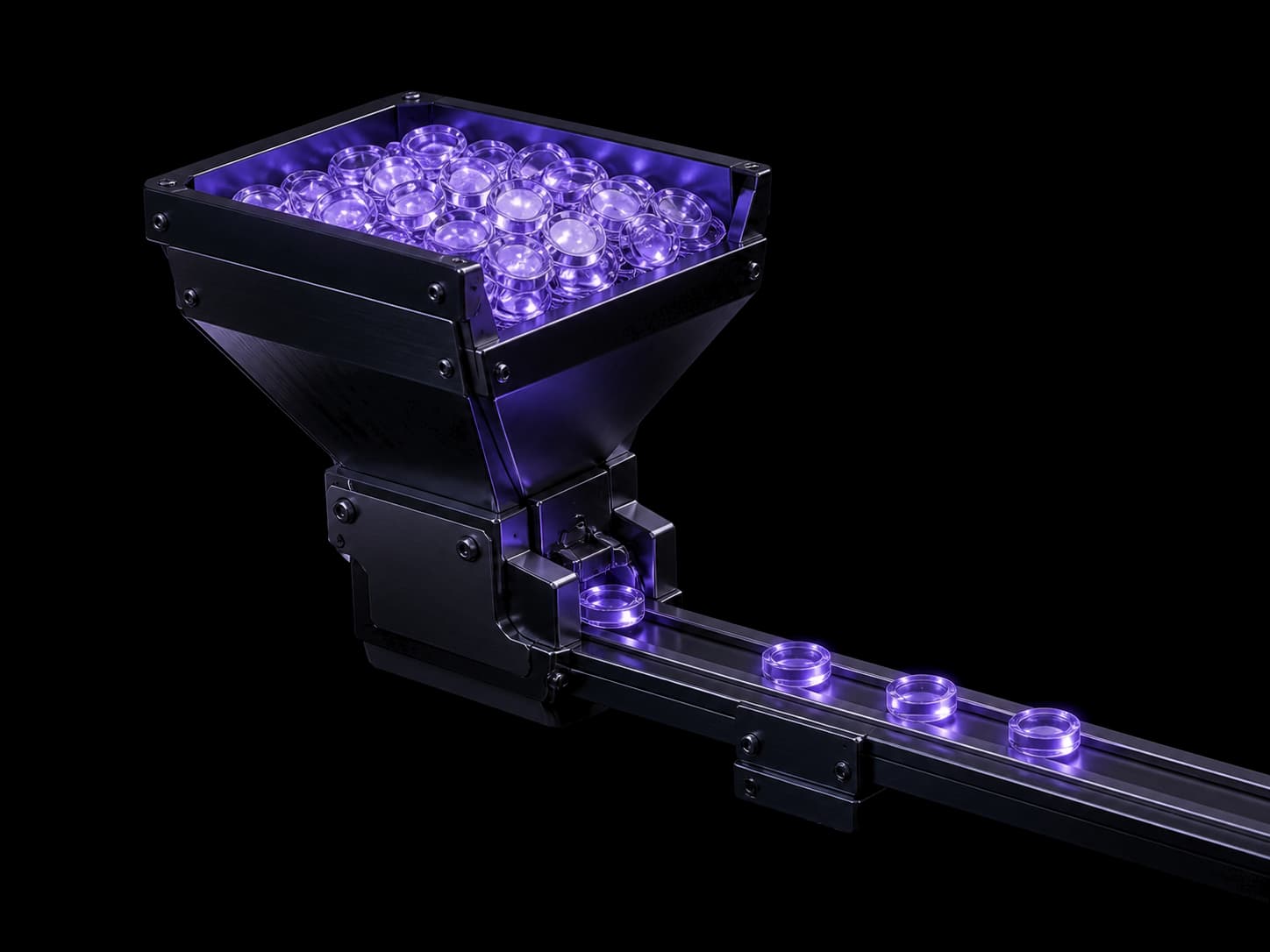 A dark hopper heaped with small violet glass beads, releasing them one at a time through a gate at its base onto a straight machined rail. Three beads sit evenly spaced along the rail.